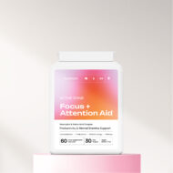 The front of a Focus + Attention aid supplement bottle on a pink platform with a white background