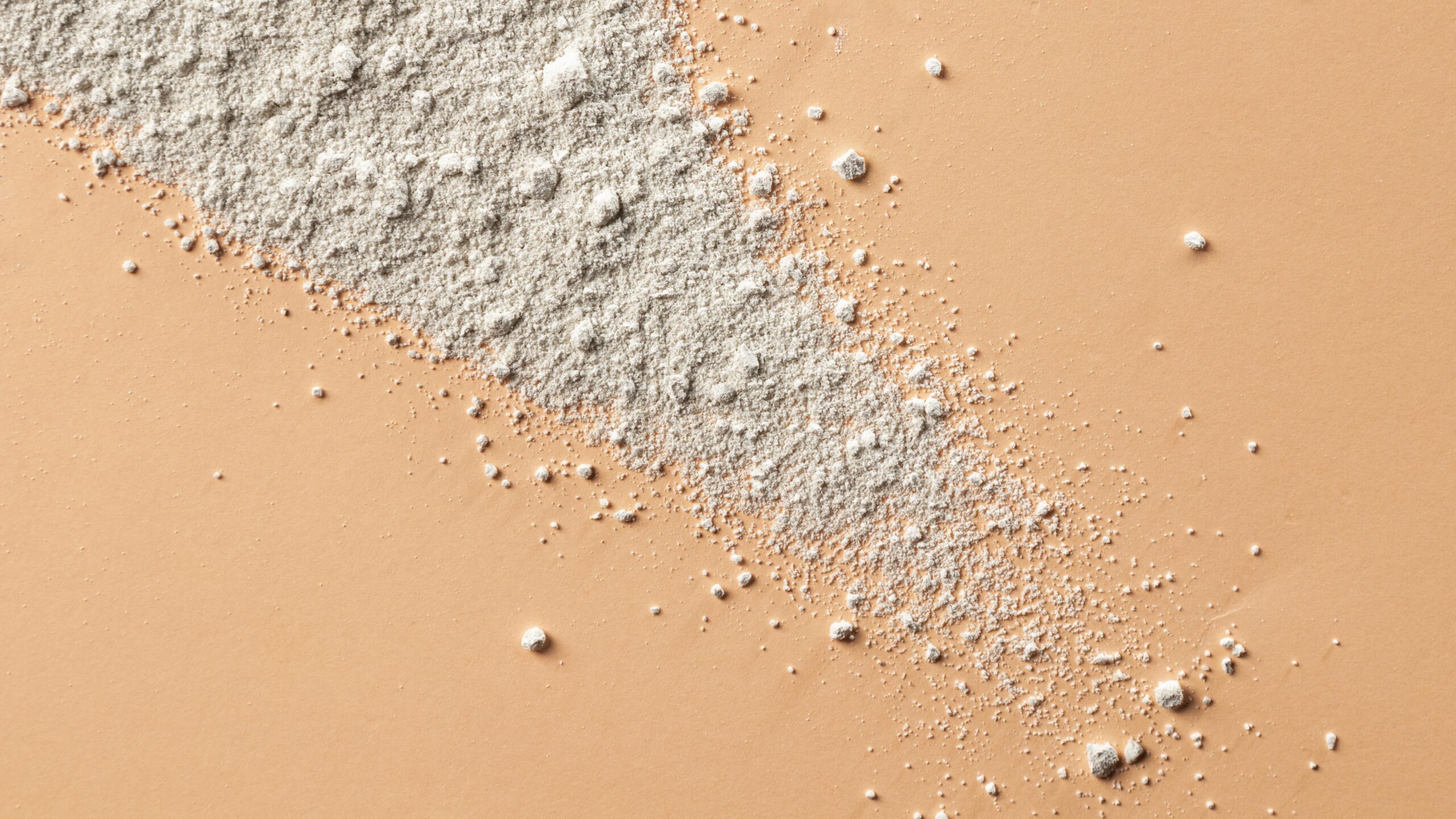 supplement ingredient powder on a peach background