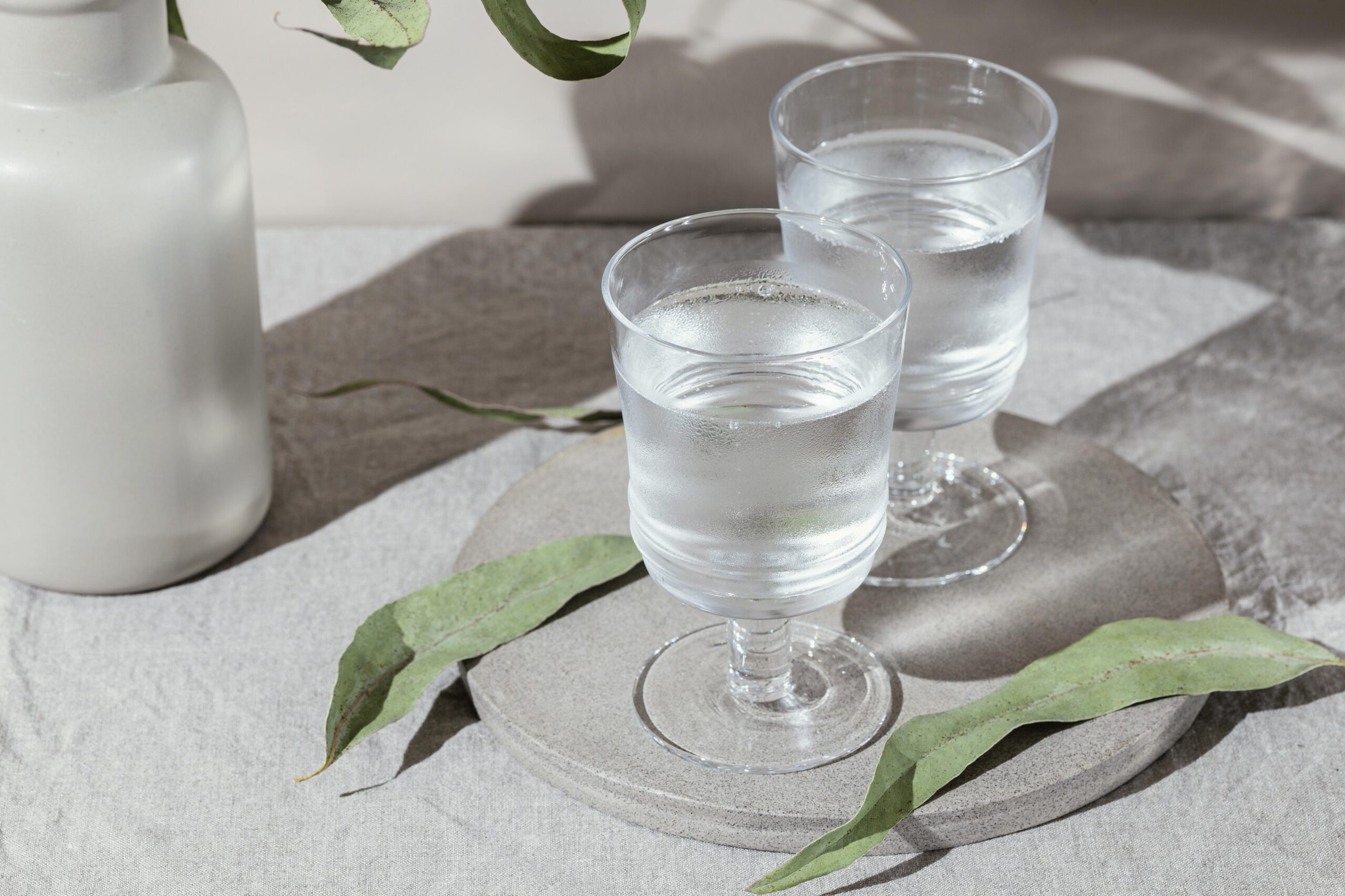 two glasses of water on a neutral coloured surface