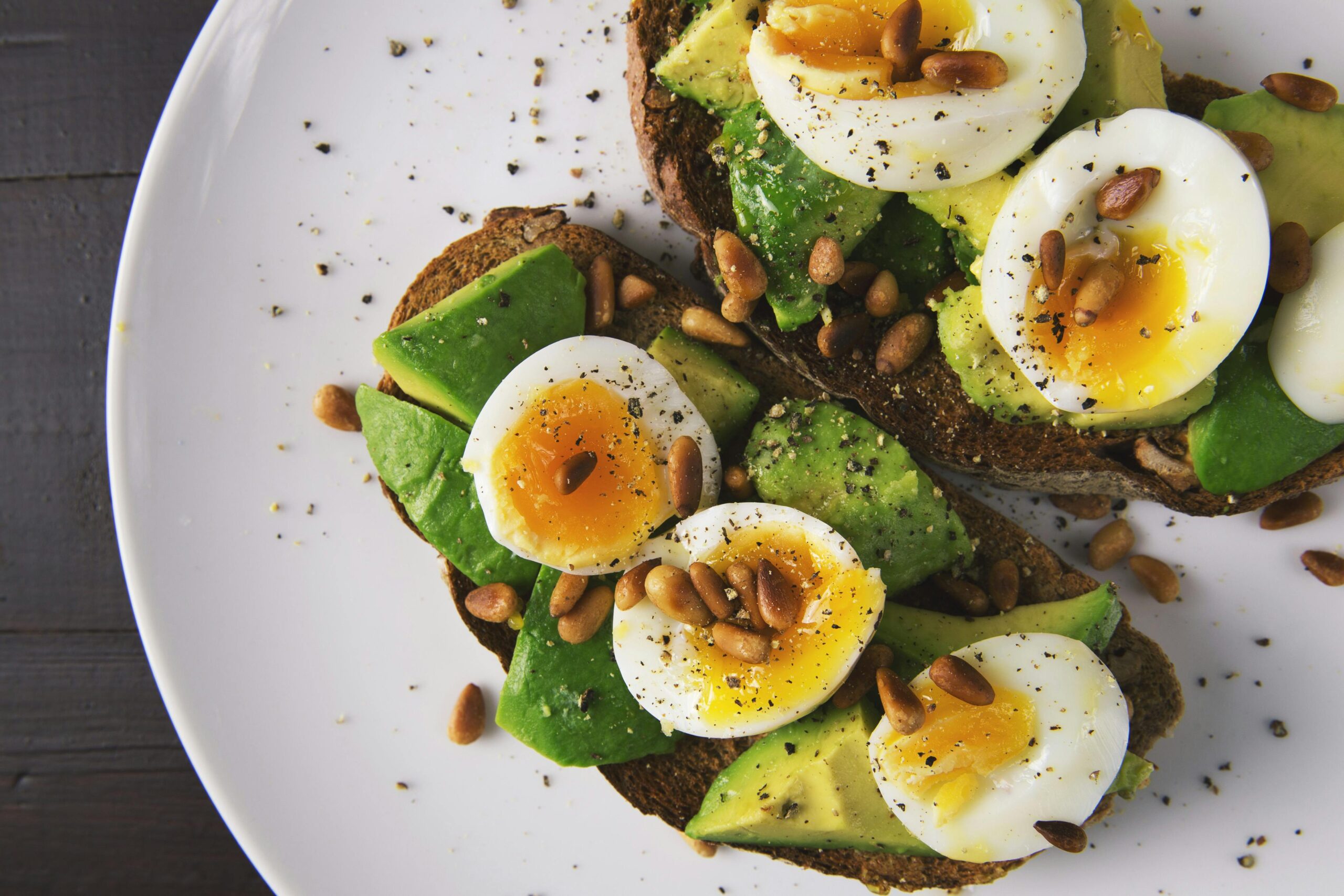 two pieces of toast with avocado and boiled egg