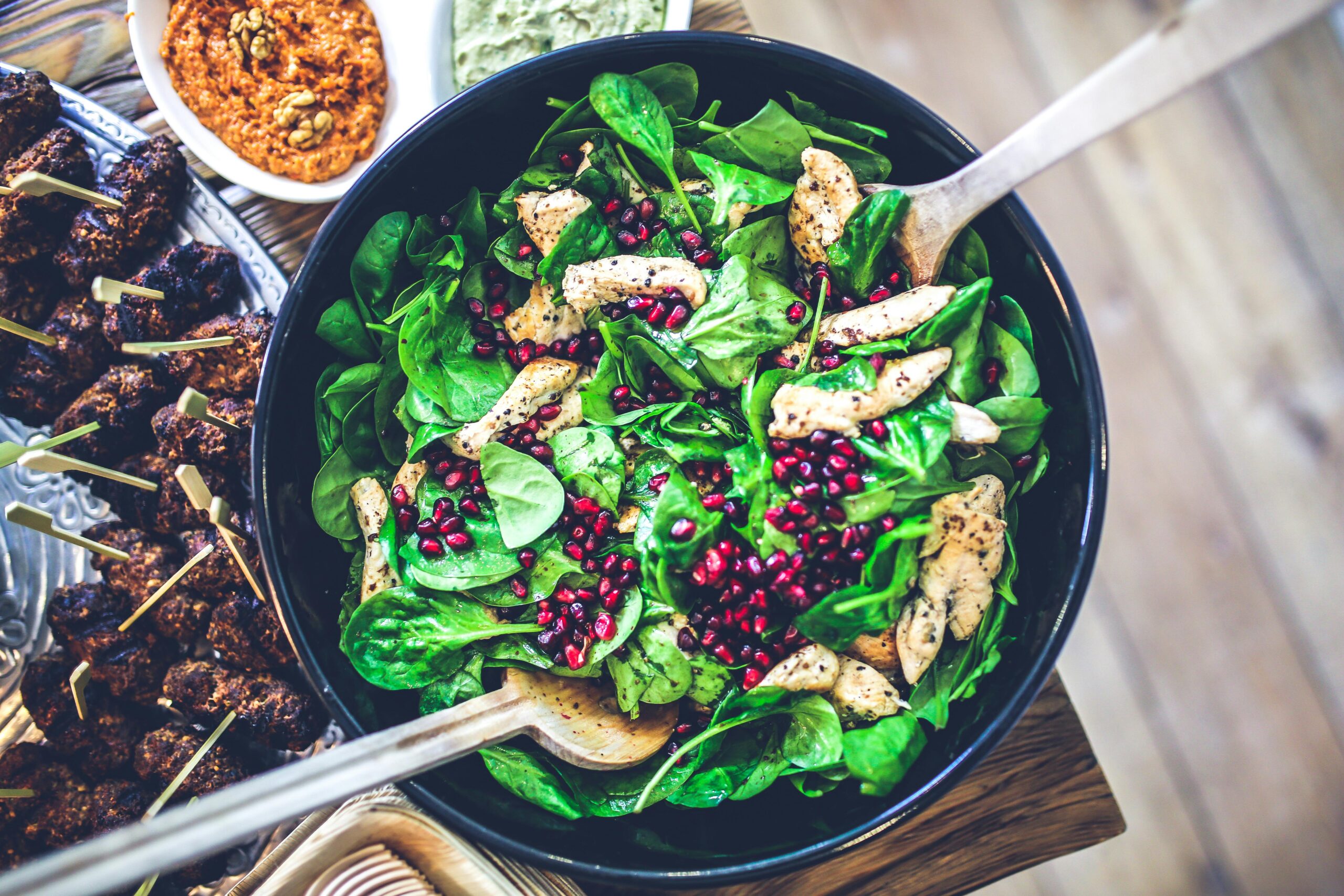 Areal view of chicken salad in a salad bowl on a table next to other healthy food