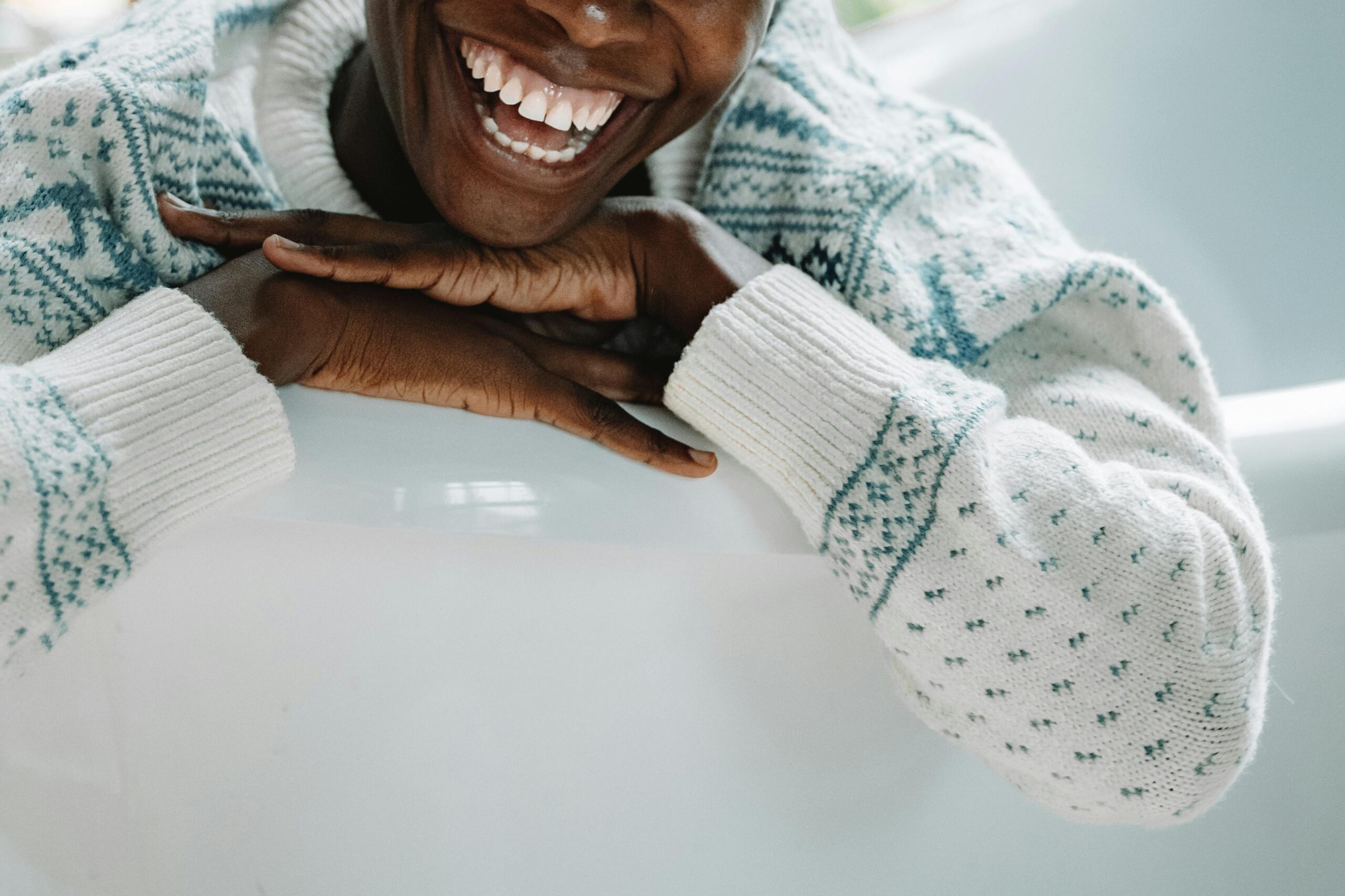 Close up of a mans smiley mouth wearing a jumper with a white background