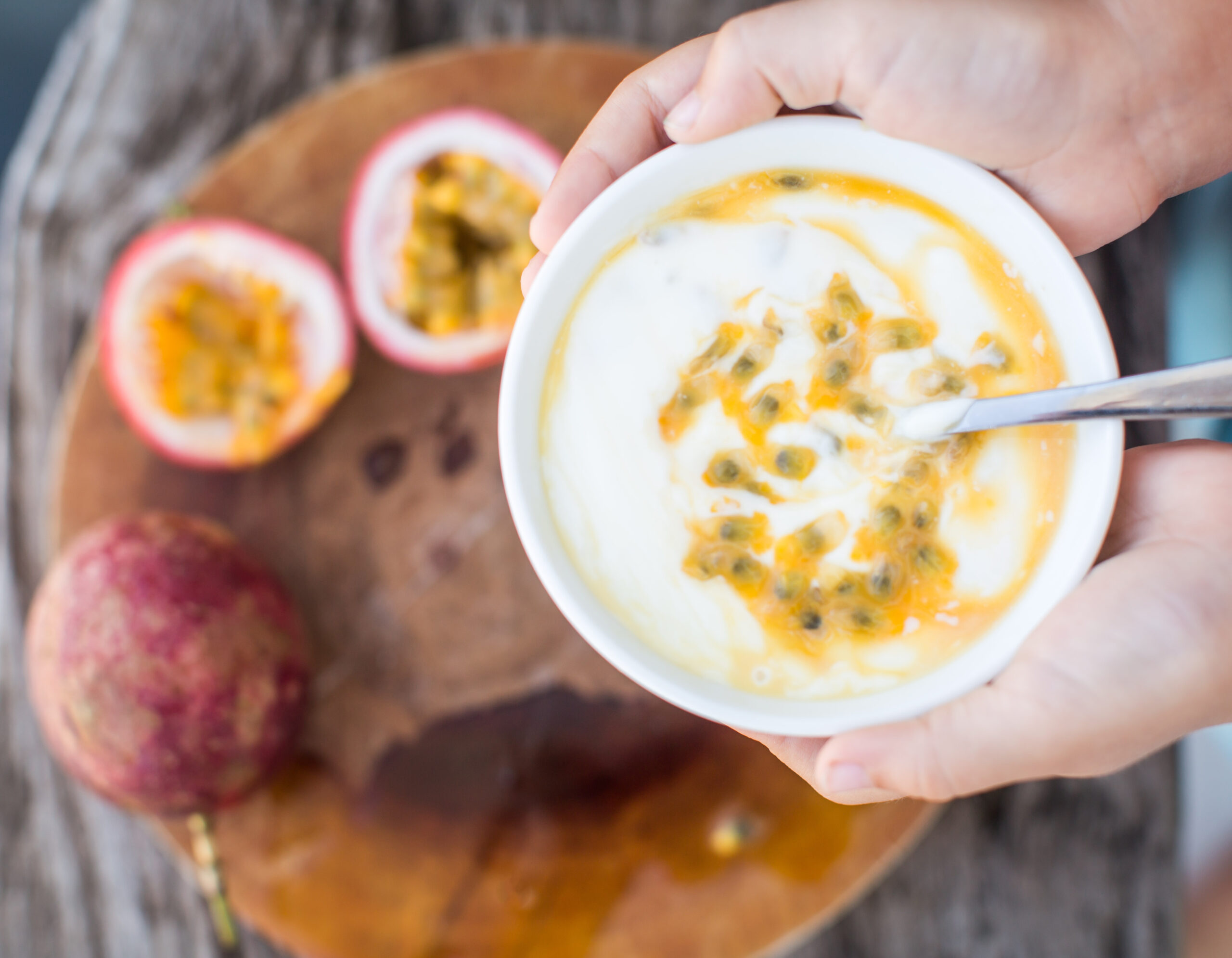 hands holding a bowl of yoghurt