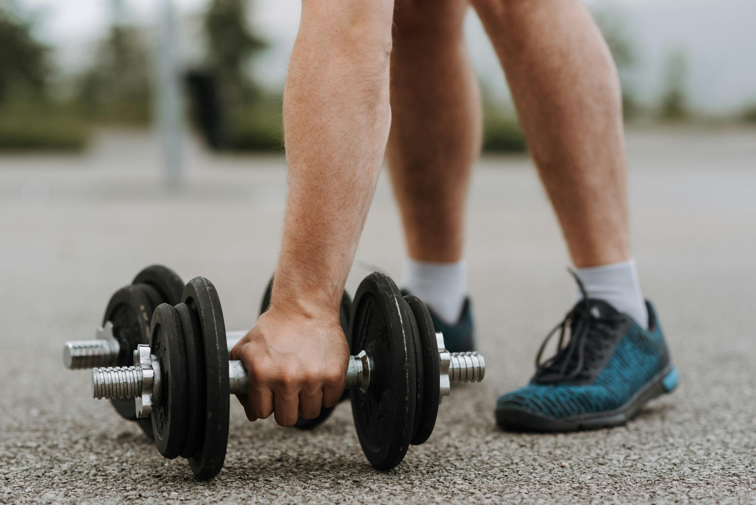 man picking up a dumbbell off the ground